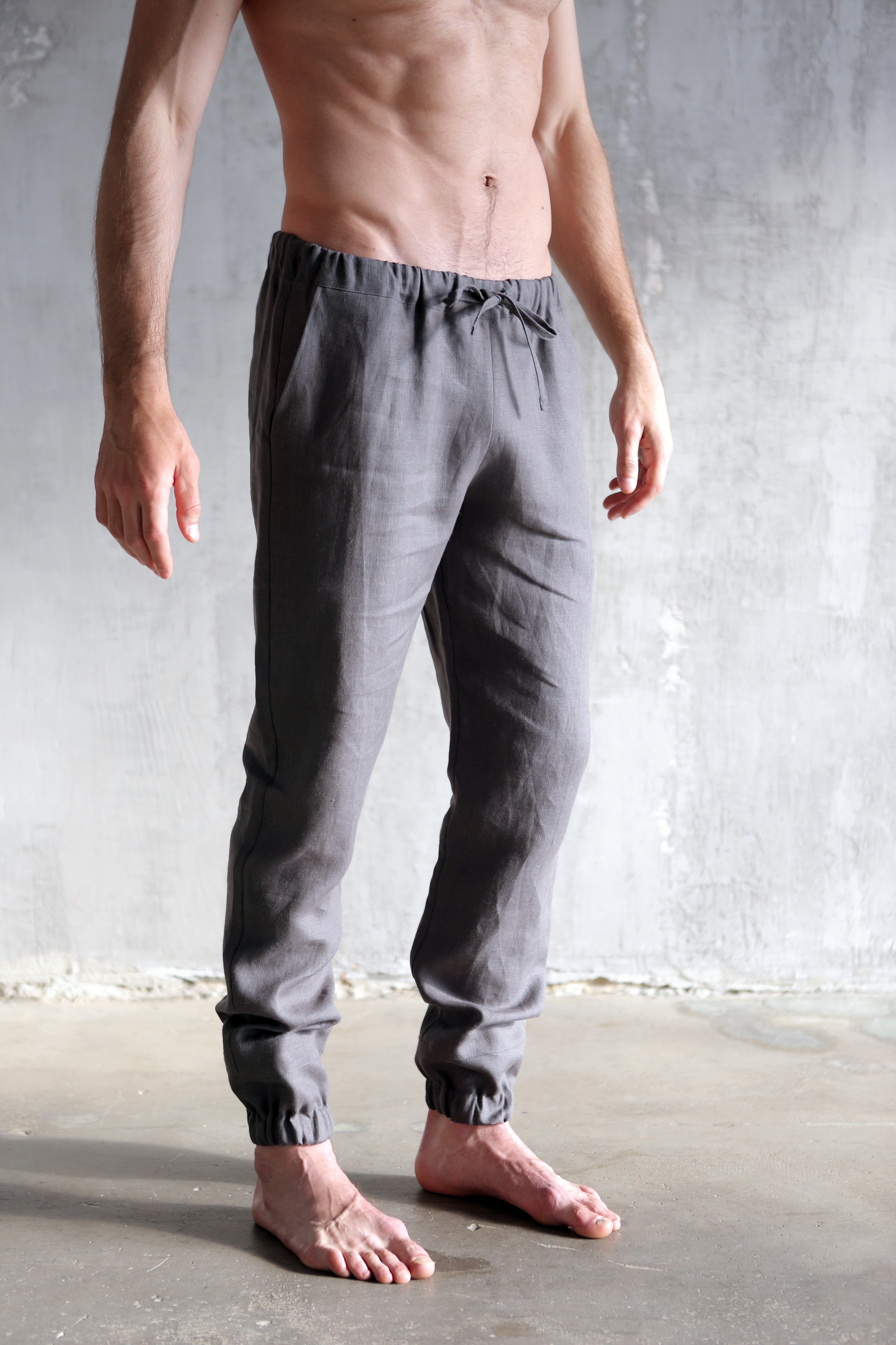 Man wearing gray jogger pants against a plain background