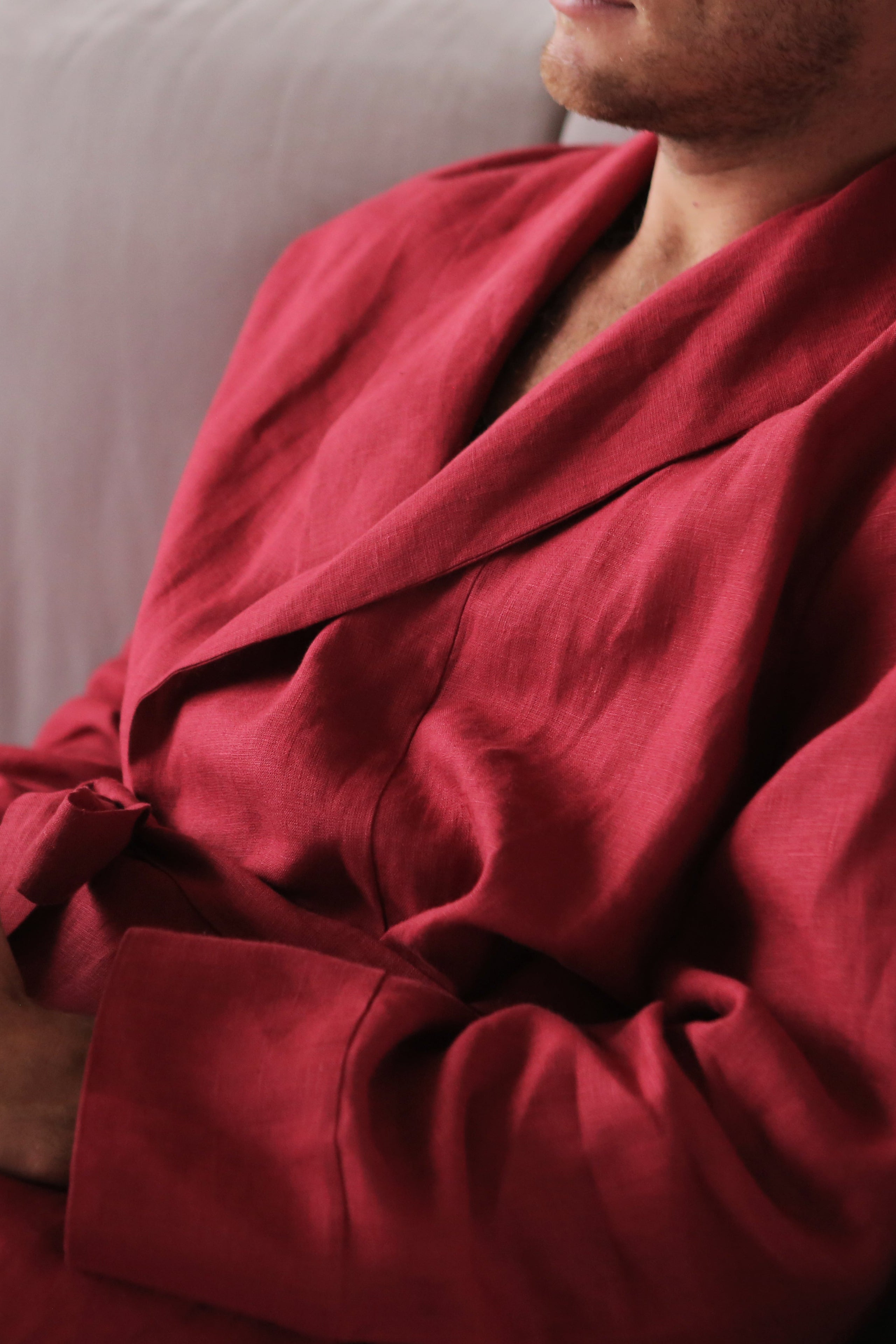 Person wearing a red robe sitting on a couch.