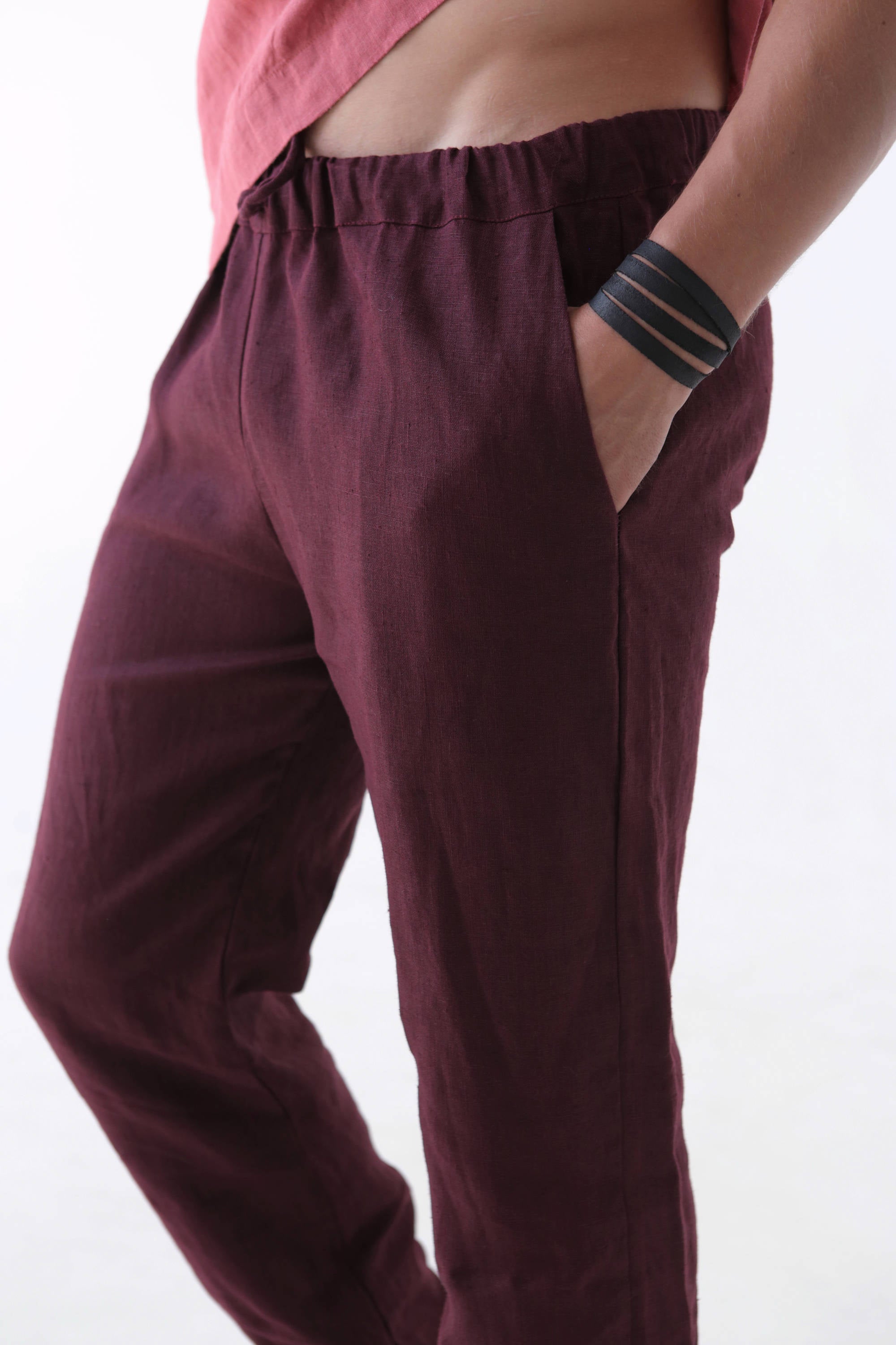 Burgundy pants worn by a person on a white background