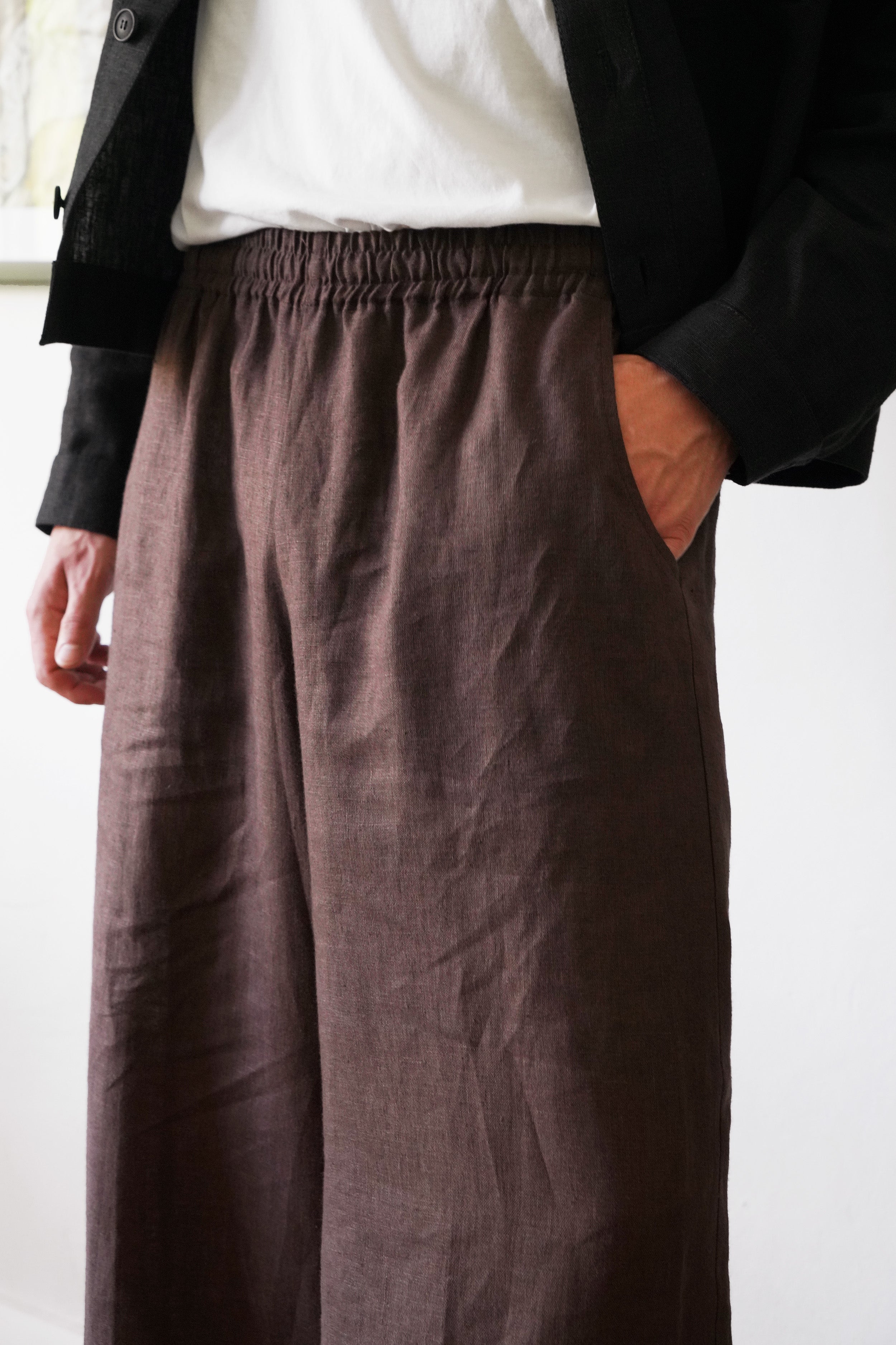 Person wearing brown wide-leg pants with a plain background