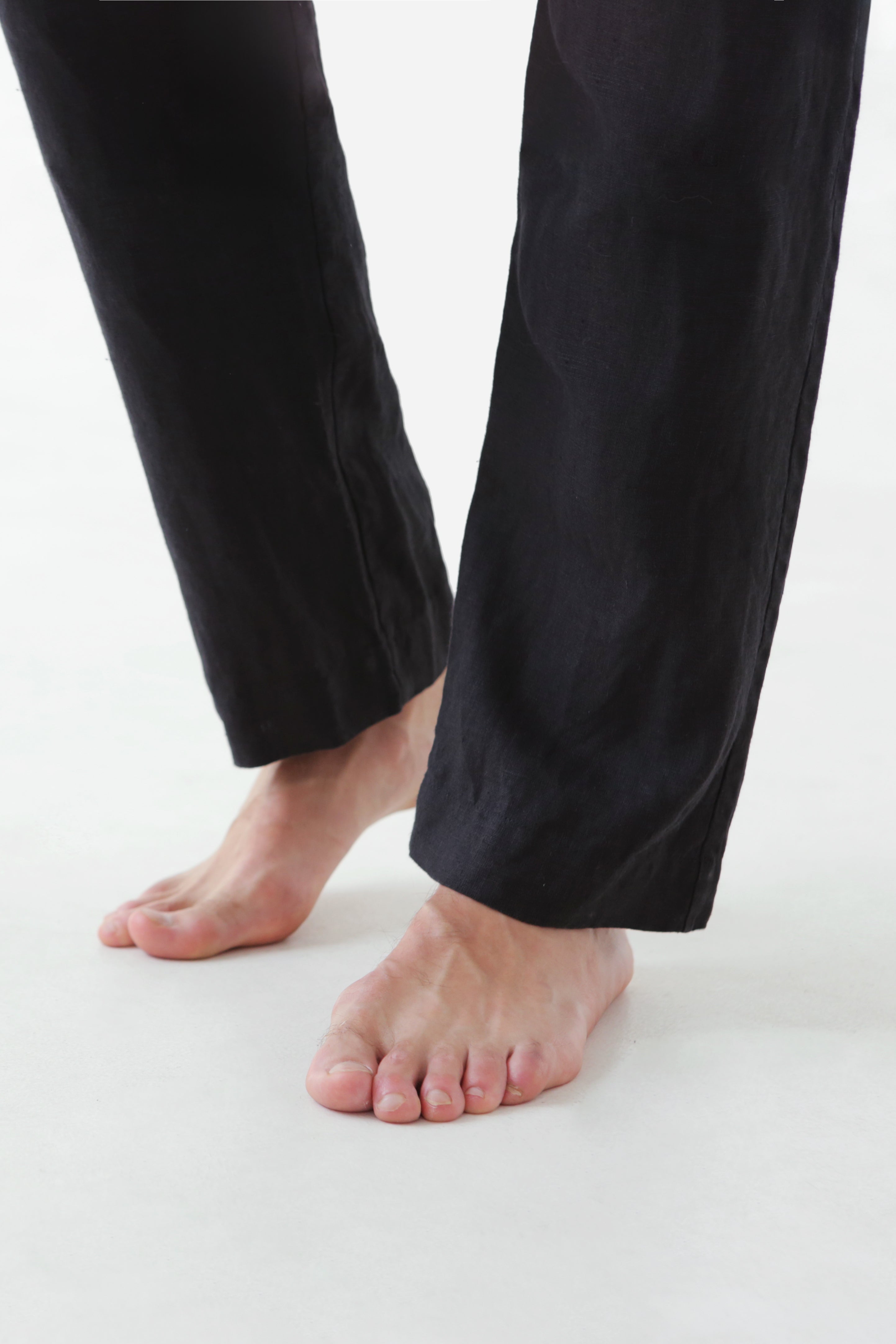 Person wearing black pants on a white background